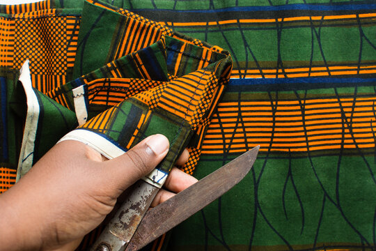 top view of cutting ankara fabric with scissors , flatlay of nigerian wax print cloth, rumpled ankara material