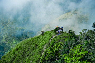 Obraz premium Adventure seekers hiking through misty hills nature trail scenic landscape mountainous region aerial perspective outdoor exploration
