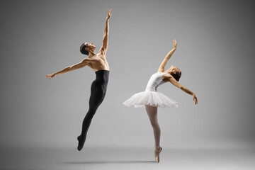 Man in black tights and woman in white tutu dress dancing ballet