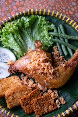 nasi ayam penyet traditional food served in a bamboo plate