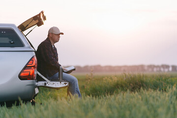 A man sits in the back of a truck, enjoying the open air and the view. © Hryhor Denys