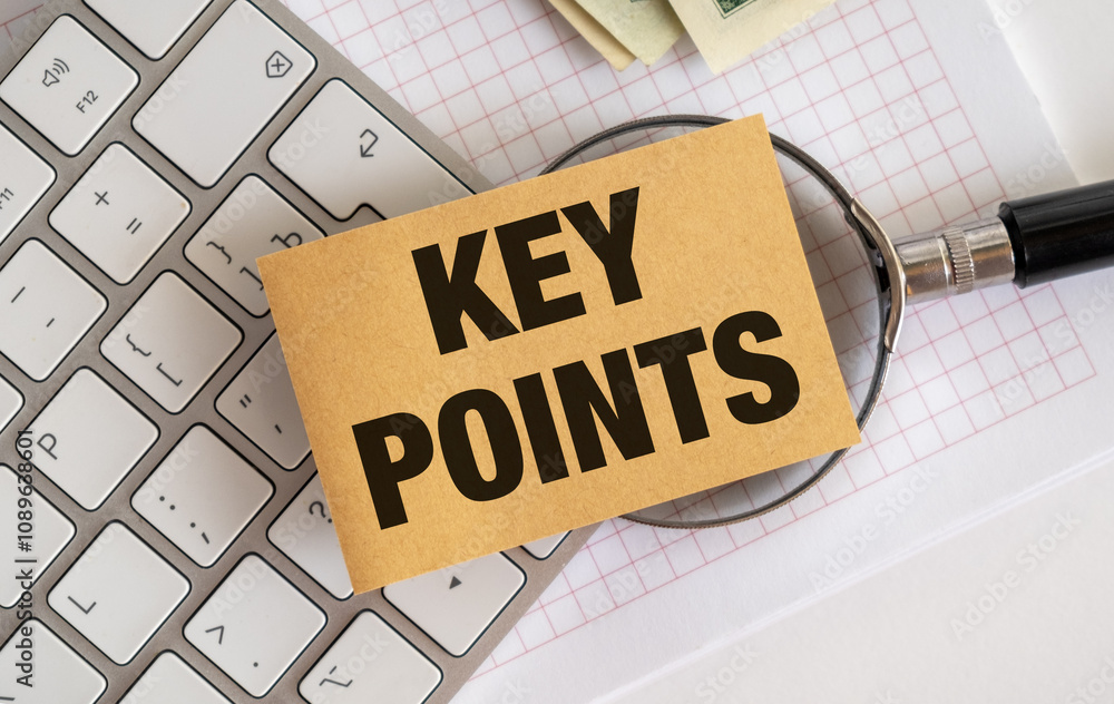 Poster close up of a notepad with the words key points written on it, keyboard and money in background