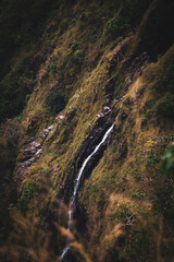 Flowing waterfall cascading down lush green hills nature scene landscape photography outdoor adventure close-up view serenity