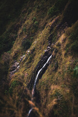 Majestic waterfall cascading down a rocky cliff serene nature scene lush green environment aerial view natural beauty