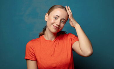 Fototapeta premium smiling cheerfully and casually, taking hand to head with a positive, happy and confident look