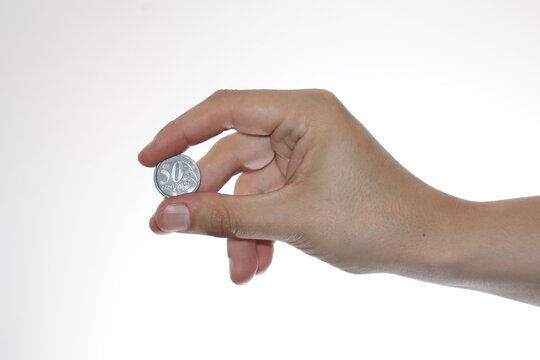 Detailed Close-Up of a Hand Holding a 50 Centavos Coin: Emphasizing the Coin's Year, Design, and Texture Against a Plain White Background
