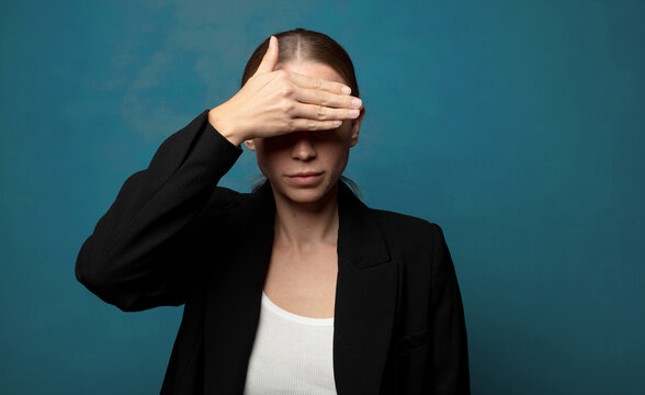 covering eyes with one hand feeling scared or anxious, wondering or blindly waiting for a surprise