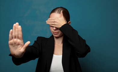 covering face with hand and putting other hand up front to stop camera, refusing photos or pictures