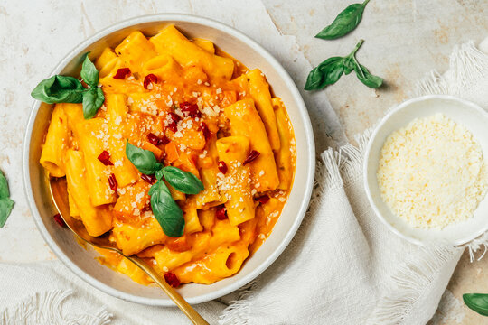 Italian rigatoni pasta with creamy pumpkin sauce, fresh spring onions and parmesan cheese