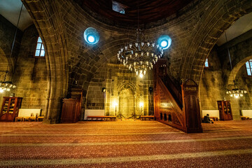 Fototapeta premium Erzurum Grand Mosque, Interior view of the mosque built of stone. Grand Mosque with its ornate chandelier and stone walls.