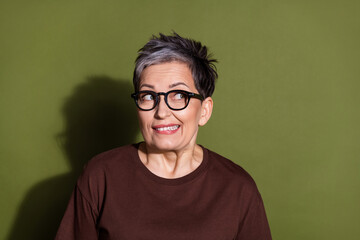 Photo portrait of gray hair beautiful cheerful senior grandmother in eyeglasses oops mistake looking novelty isolated on khaki color background