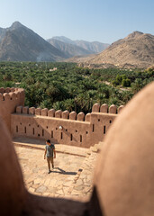A man explores the historic Nakhal Fort in Oman, a stunning example of traditional Omani...
