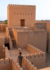 A man explores the historic Nizwa Fort in Oman, a remarkable symbol of the country’s rich heritage and architectural ingenuity. 