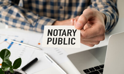 NOTARY PUBLIC is written in a white notepad near a calculator, coffee, glasses and a pen. Business concept