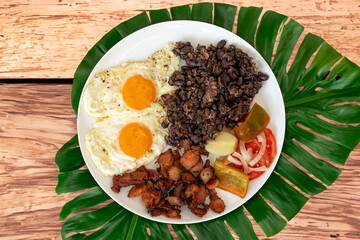 Traditional Brazilian everyday food, black bean stew, bacon, egg, salad, pickles. Real rustic food