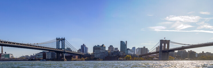 Obraz premium Brooklyn Bridge, Manhattan Bridge, Brooklyn Waterfront Panorama, and East River Bank viewed from New York City's Lower Manhattan waterfront 