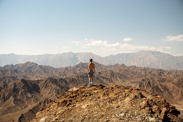 Man Standing on Top of Al Hajar Mountain Peak in Oman