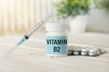 Pills with the text VITAMIN B2 on wooden background. Medical concept.