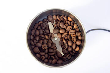Fototapeta premium Coffee beans inside a coffee grinder machine background.