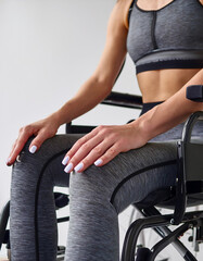 Obraz premium young woman's hands in a wheelchair wearing sportswear, symbolizing inclusion and an active lifestyle
