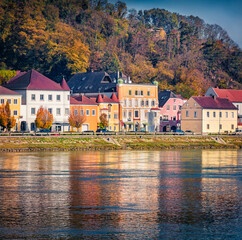 Fototapeta premium Colorful buildings on the shore of Danube river. Attractive autumn cityscape of Mauthausen market town in state of Upper Austria, Europe. Traveling concept background..