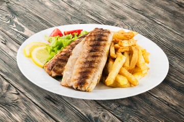Fried tasty fish steak with cooked gvegetables