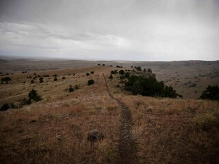 Bike trail on grassy mesa in Del Norte Colorado in fall with stormy sky