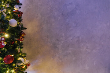 Gray wall with Christmas tree and lights garland as background © dmitriisimakov