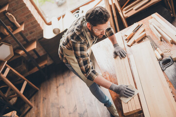 Fototapeta premium Top photo of builder workman guy focused working with wood plank on desk garage