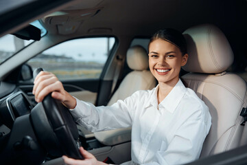Woman, car, driving, smiling a happy woman sits in the driver's seat of a car with her hands on the...