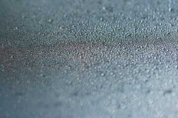 Krople wody. Jasne niebieskie tło. Tekstura kropli wody na płaskiej powierzchni i bokeh kropelkowy