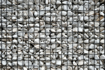 Fragment of Modern Gabion fence with stones in wire mesh. Gabion wire mesh fencing with natural...