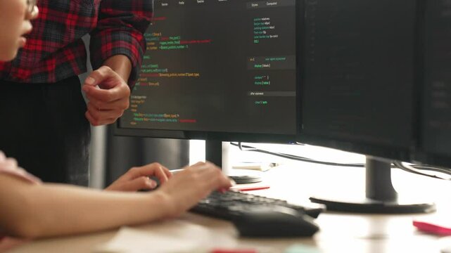 Slow motion back end or software developer manager supervising his team on new application program development on debugging and solving complex code algorithms on monitor. Burgeoning