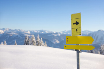 Skiing in the mountains. Yellow directional signs with a snowy background
