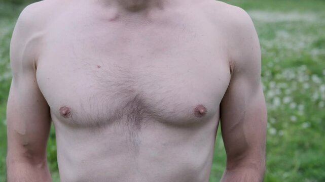 Man breathes slowly in nature, showcasing a rising and falling chest in serene slow motion