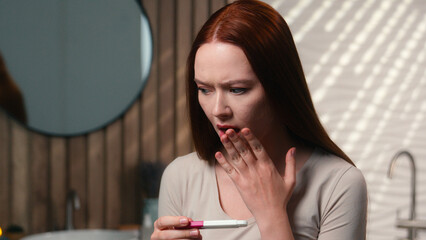 Pregnant Caucasian woman future mother female in home bathroom stressed sad confused girl check...