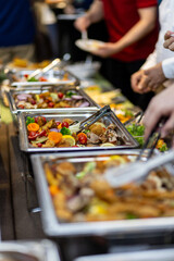 Obraz premium Buffet featuring a variety of fresh salads and main dishes at a lively gathering event