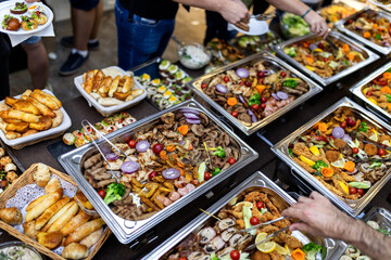 Fototapeta premium Buffet featuring a variety of meats, vegetables, and sides at an indoor gathering