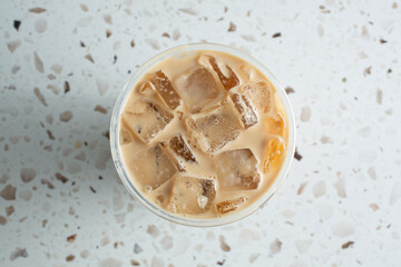 A top down view of a cup of iced chai latte. © DAVID