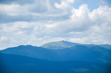 Obraz premium Serene mountain landscape of Pip Ivan Chonohora mountain peak with old observatory under a cloudy blue sky. Picturesque view capturing the tranquility and majesty of nature. Carpathians, Ukraine