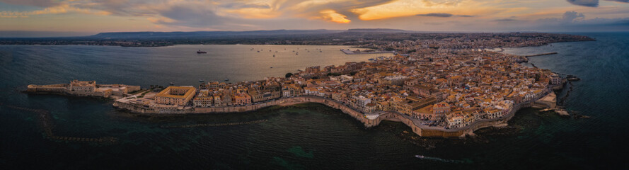 Siracusa, Ortigia Island from the air at sunset, Sicily, Italy. Isola di Ortigia, coast of Ortigia island at city of Syracuse, Sicily, Italy. Aerial view. June 2023