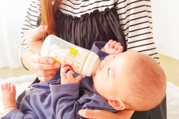 哺乳瓶からミルクを飲むアジア人の赤ちゃん