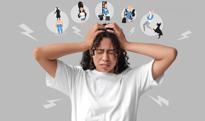Young African-American woman having panic attack on grey background