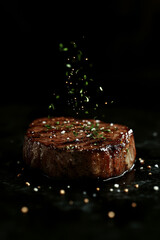 Tender steak with sprinkling herbs captured with black background