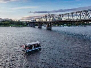 Water taxi on the Ottawa River next to the Alexandra Bridge, Ottawa, Ontario, Canada.