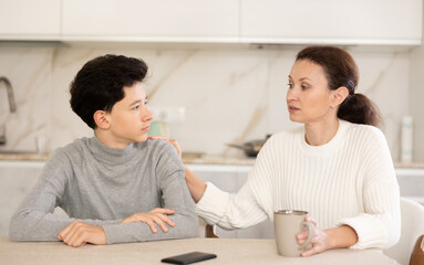 Fototapeta premium Mother and son discussing something, boy is very attentive