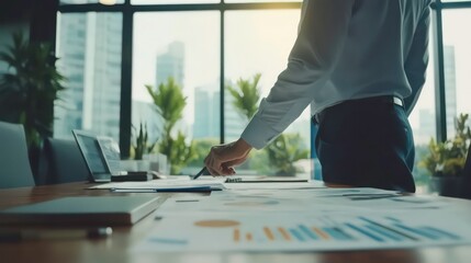 Businessman standing in front of a conference table reviewing documents.