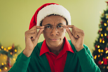 Photo of nice young man touch spectacles skeptical wear green christmas clothes enjoy cozy x-mas...