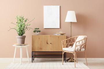 Chest of drawers, armchair, floor lamp, houseplant and picture on brown wall in room