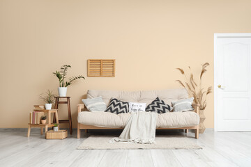 Cozy sofa, houseplants and pampas grass in interior of living room